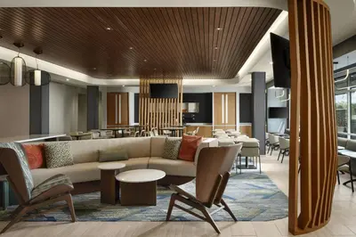 a lobby with a couch and chairs and a restaurant at SpringHill Suites by Marriot Troy Dayton in Troy