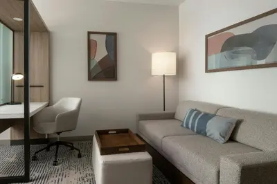 a living room with a couch and a chair in a hotel room at SpringHill Suites by Marriot Troy Dayton in Troy