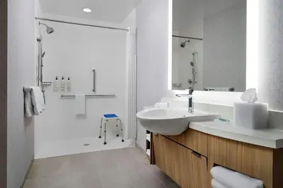 a white bathroom with a sink and a shower at SpringHill Suites by Marriot Troy Dayton in Troy