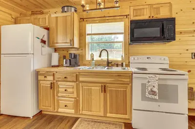 a kitchen with a white refrigerator and a sink at On 40 Acres Charming Cabin in Zanesville! in Zanesville