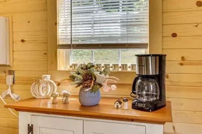 a kitchen counter with a blender and a vase of flowers at On 40 Acres Charming Cabin in Zanesville! in Zanesville