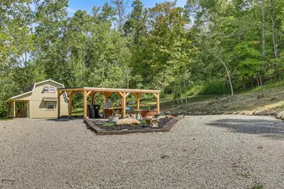 a house with a gazebo on a gravel driveway at On 40 Acres Charming Cabin in Zanesville! in Zanesville