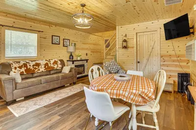 a living room with a table and a couch at On 40 Acres Charming Cabin in Zanesville! in Zanesville