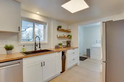 a kitchen with white cabinets and a sink and a window at 3 Mi to Dtwn and YSU Updated Youngstown Home in Youngstown