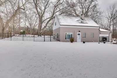 a white house with a snow covered driveway at 3 Mi to Dtwn and YSU Updated Youngstown Home in Youngstown