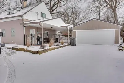 a house with a white garage in the snow at 3 Mi to Dtwn and YSU Updated Youngstown Home in Youngstown