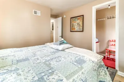 a bedroom with a bed with a blue and white quilt at Walk to Adrian College Family Home in Michigan in Adrian