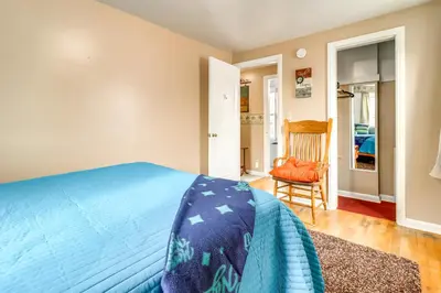 a bedroom with a blue bed and a chair at Walk to Adrian College Family Home in Michigan in Adrian