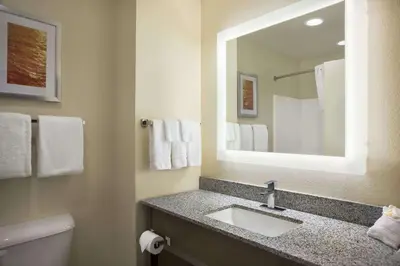 a bathroom with a sink and a mirror at Days Inn & Suites by Wyndham Belmont in Belmont