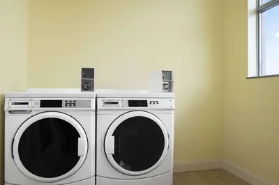 two washing machines in a room with a window at Days Inn & Suites by Wyndham Belmont in Belmont