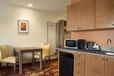 a small kitchen with a table and a microwave at Days Inn & Suites by Wyndham Belmont in Belmont