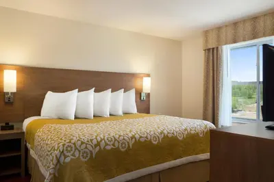 a hotel room with a bed with a large window at Days Inn & Suites by Wyndham Belmont in Belmont