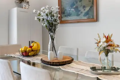 a dining room table with a vase of flowers on it at Italian Village Gem, Downtown, Free Parking, OSU in Columbus