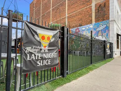 a sign on a gate with a late night slice sign on it at Italian Village Gem, Downtown, Free Parking, OSU in Columbus