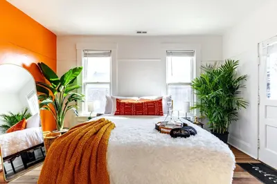 a bedroom with a large bed with orange walls at Jungle House Columbus Downtown Free Parking Sleeps 8 - Near Convention Center & Nationwide Arena - 2BR Luxury Home - Pet Friendly Over 5,800 Five Star Stays in Columbus
