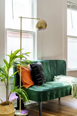 a green couch with pillows on it in a living room at Jungle House Columbus Downtown Free Parking Sleeps 8 - Near Convention Center & Nationwide Arena - 2BR Luxury Home - Pet Friendly Over 5,800 Five Star Stays in Columbus