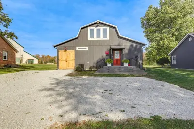 a gray house with a red door on a gravel driveway at 5 Mi to WEC Pet-Friendly Home in Wilmington in Wilmington