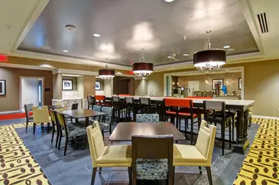 a restaurant with tables and chairs and a bar at Hampton Inn and Suites Cincinnati - Downtown in Cincinnati