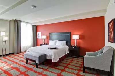 a hotel room with a bed and a red wall at Hampton Inn and Suites Cincinnati - Downtown in Cincinnati