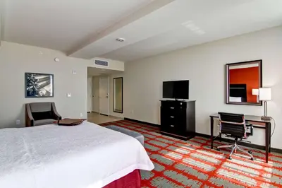 a hotel room with a bed and a desk and a tv at Hampton Inn and Suites Cincinnati - Downtown in Cincinnati