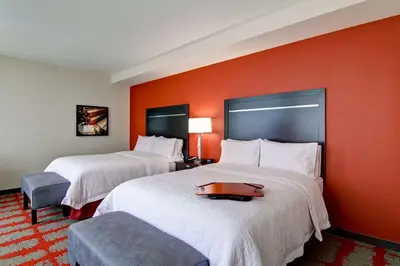 two beds in a hotel room with orange walls at Hampton Inn and Suites Cincinnati - Downtown in Cincinnati