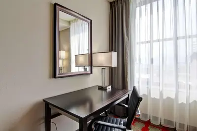 a desk in a hotel room with a mirror and a window at Hampton Inn and Suites Cincinnati - Downtown in Cincinnati