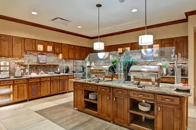 a large kitchen with wooden cabinets and granite counter tops at Homewood Suites by Hilton Cincinnati-Downtown in Cincinnati