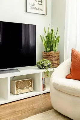 a living room with a television on a white entertainment center at Lux Condo Steps to Washington Park - Walk to ALL in Cincinnati