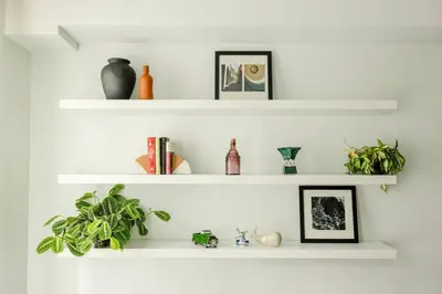 a room with white shelves with plants and pictures at Lux Condo Steps to Washington Park - Walk to ALL in Cincinnati