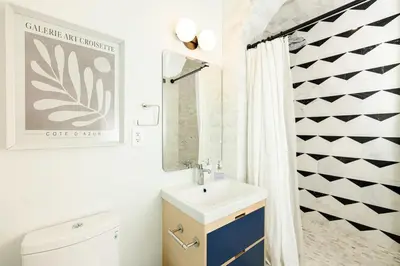 a bathroom with a sink and a toilet and a shower at Lux Condo Steps to Washington Park - Walk to ALL in Cincinnati