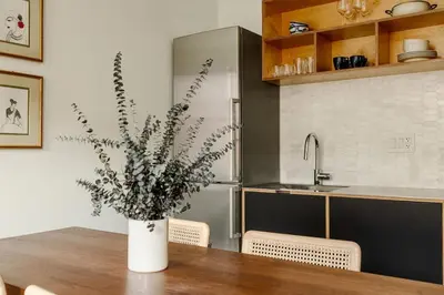 a vase of flowers sitting on a table in a kitchen at Lux Condo Near Washington Park - Walk Everywhere in Cincinnati