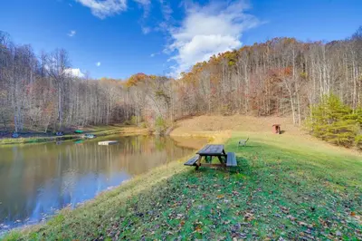 a picnic table sitting next to a river at Shared Pond and Trails Rosedale Cottage! in Rosedale