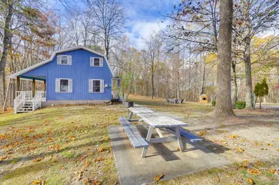 a blue house with a picnic table in front of it at Shared Pond and Trails Rosedale Cottage! in Rosedale