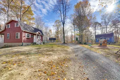 an empty road in front of a red house at Shared Pond at Retreat in Rosedale! in Rosedale