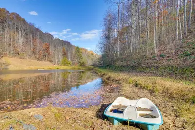 a boat sitting on the side of a river at Shared Pond at Retreat in Rosedale! in Rosedale