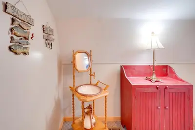 a room with a mirror and a chair and a red cabinet at Picnics and Bonfires Rosedale Retreat! in Rosedale