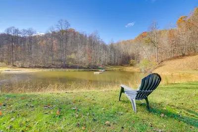 a chair sitting in the grass next to a lake at Picnics and Bonfires Rosedale Retreat! in Rosedale