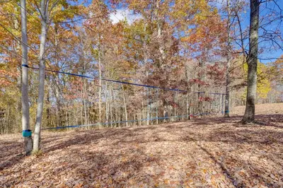 a fence in the middle of a forest at Picnics and Bonfires Rosedale Retreat! in Rosedale