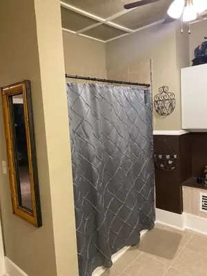 a shower with a gray shower curtain in a room at Charming Wheeling Island Home in Wheeling