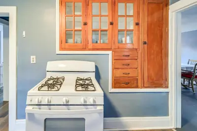 a white stove in a kitchen with a cabinet at 1 Block to Downtown Adrian Spacious Home! in Adrian
