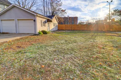 a large yard with a house and a fence at 1 Block to Downtown Adrian Spacious Home! in Adrian