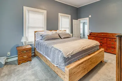 a bedroom with a bed with a wooden frame and dresser at 1 Block to Downtown Adrian Spacious Home! in Adrian
