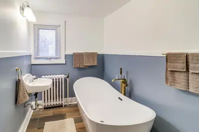 a bathroom with a white tub and a sink at 1 Block to Downtown Adrian Spacious Home! in Adrian