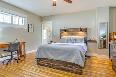 a bedroom with a bed and a desk and a chair at East End River Retreat Dogs Welcome! in Madison