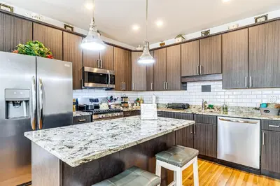 a kitchen with stainless steel appliances and wooden cabinets at East End River Retreat Dogs Welcome! in Madison