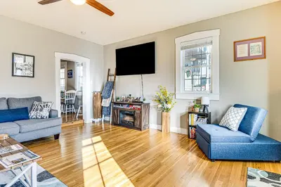 a living room with two blue chairs and a tv at East End River Retreat Dogs Welcome! in Madison