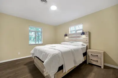 a bedroom with a large bed with a wooden headboard at Tranquil Stay in Columbus in Gahanna