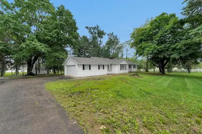 a small white house in a field with trees at Tranquil Stay in Columbus in Gahanna