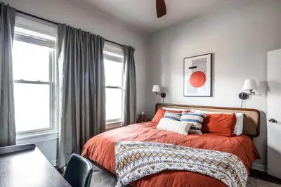 a bedroom with a bed and two windows at Mid-Century Modern Retreat in Little Italy in Cleveland