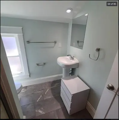 a bathroom with a sink and a mirror at Beautiful Home Near Downtown & Cultural Gardens! in Cleveland